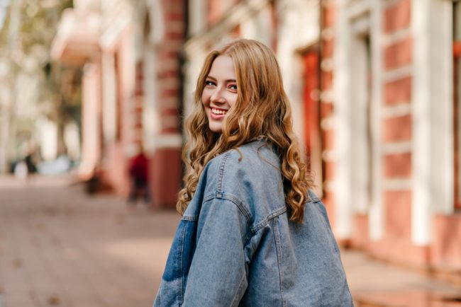 Portrait,Of,A,Blonde,Curly,Haired,Woman,Walking,On,The cosmetic dentistry alexandria