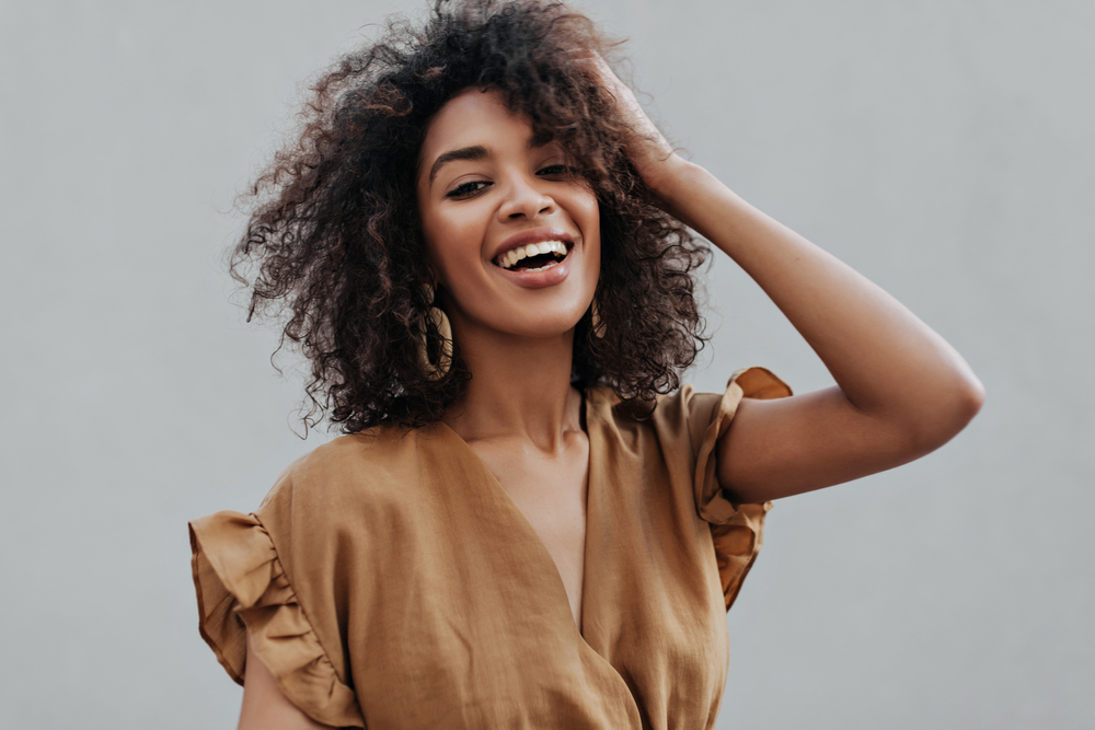 Portrait,Of,Curly,Brunette,African,Dark-skinned,Woman,In,Beige,Top smile design alexandria