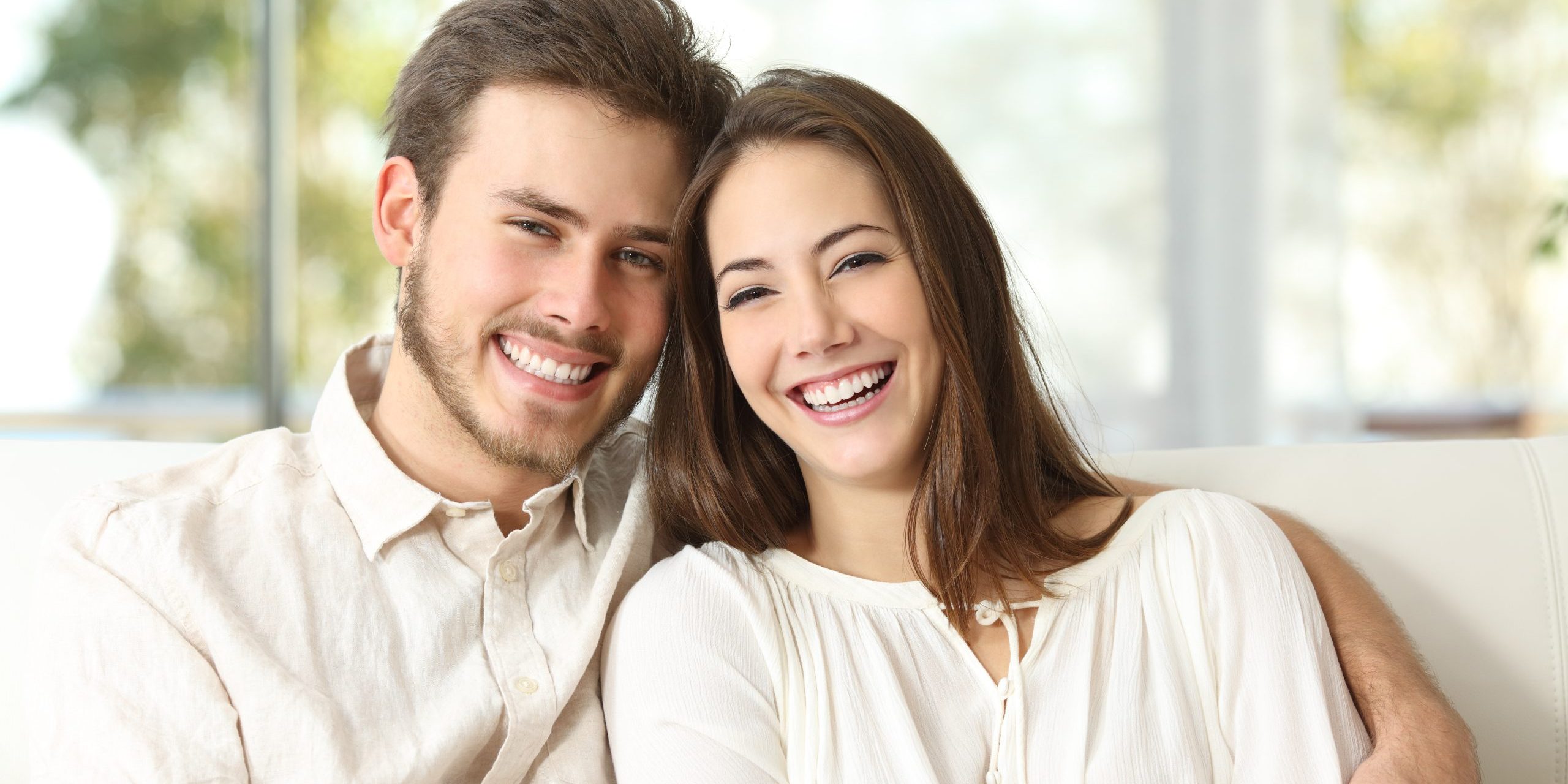 Happy,Couple,Sitting,On,A,Couch,At,Home,And,Looking dental exams alexandria