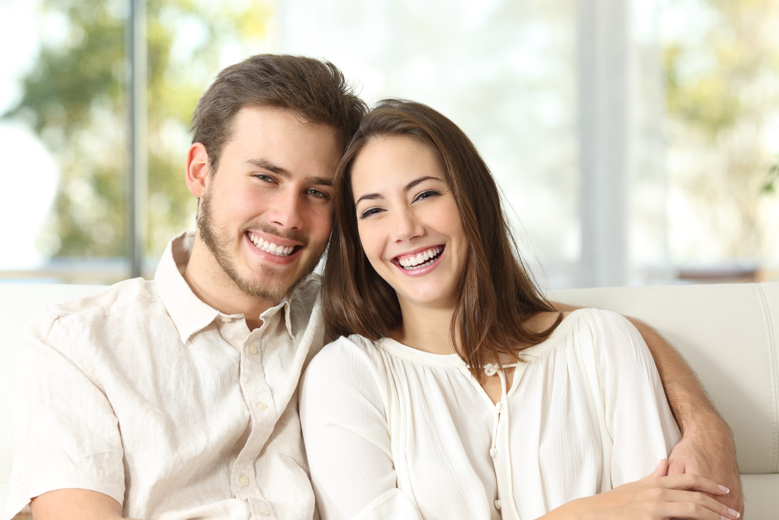 Happy,Couple,Sitting,On,A,Couch,At,Home,And,Looking dental exams alexandria